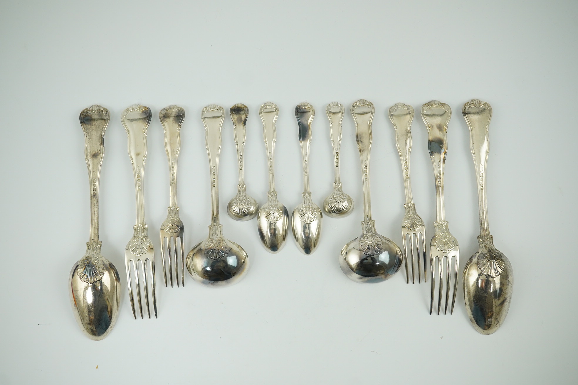 A matched part canteen of George IV and later silver shell scroll pattern flatware